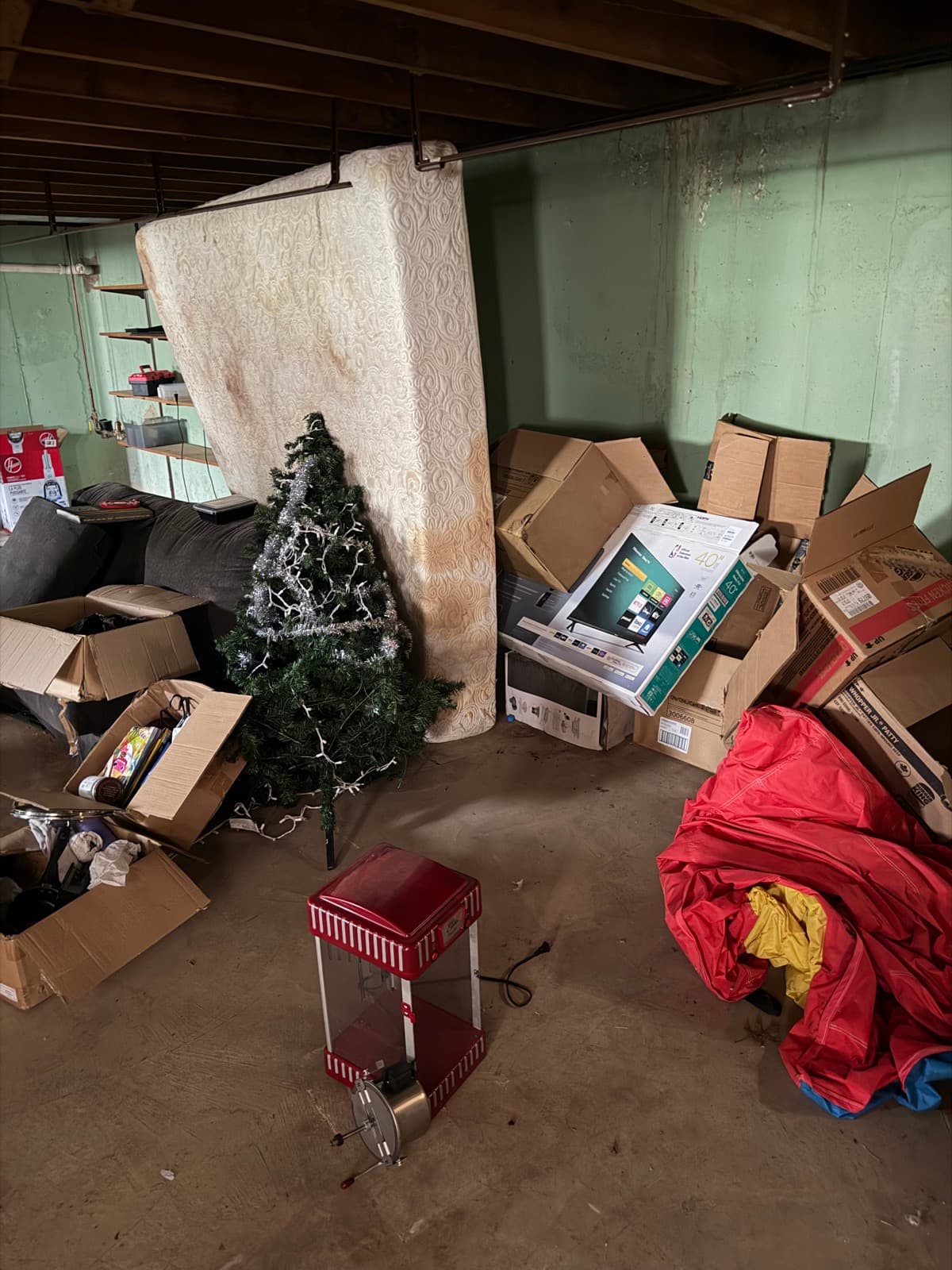 Boxes, holiday décor, a propped mattress, and household clutter packed into a residential basement before The Junk Lord pickup in York County, PA