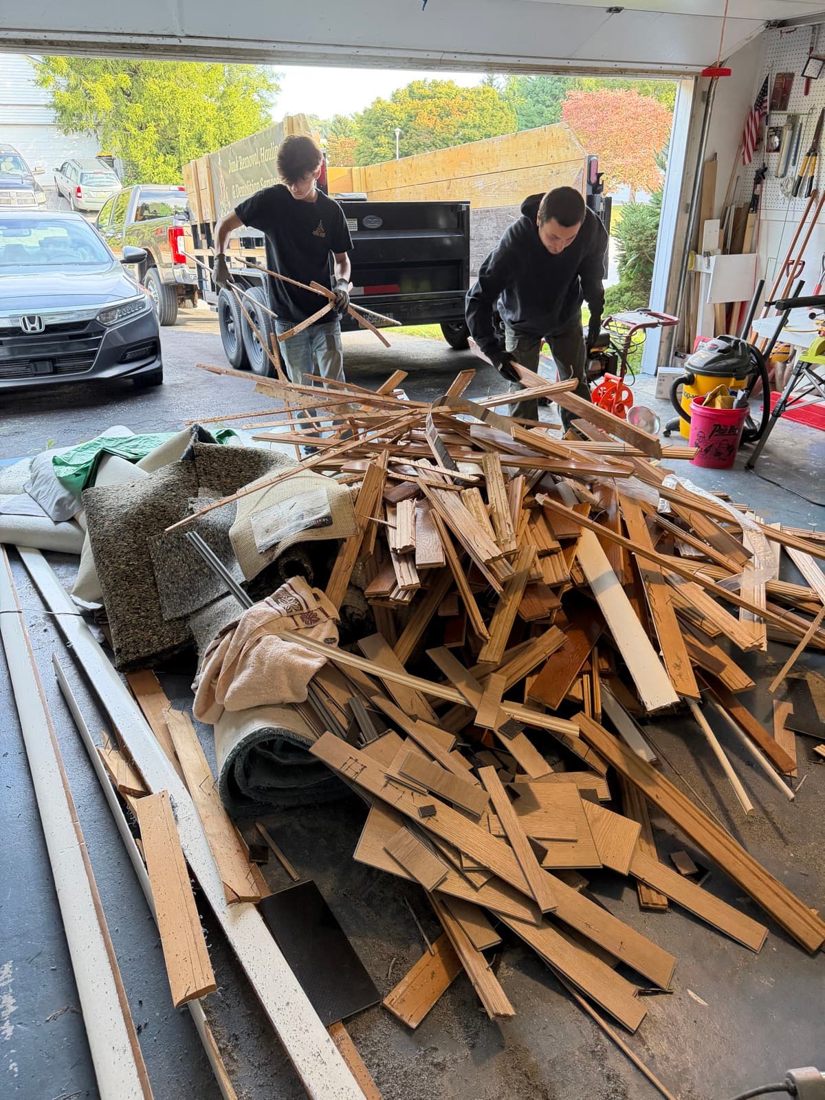 Junk Lord crew clearing stacked hardwood flooring from a residential garage in York County, PA