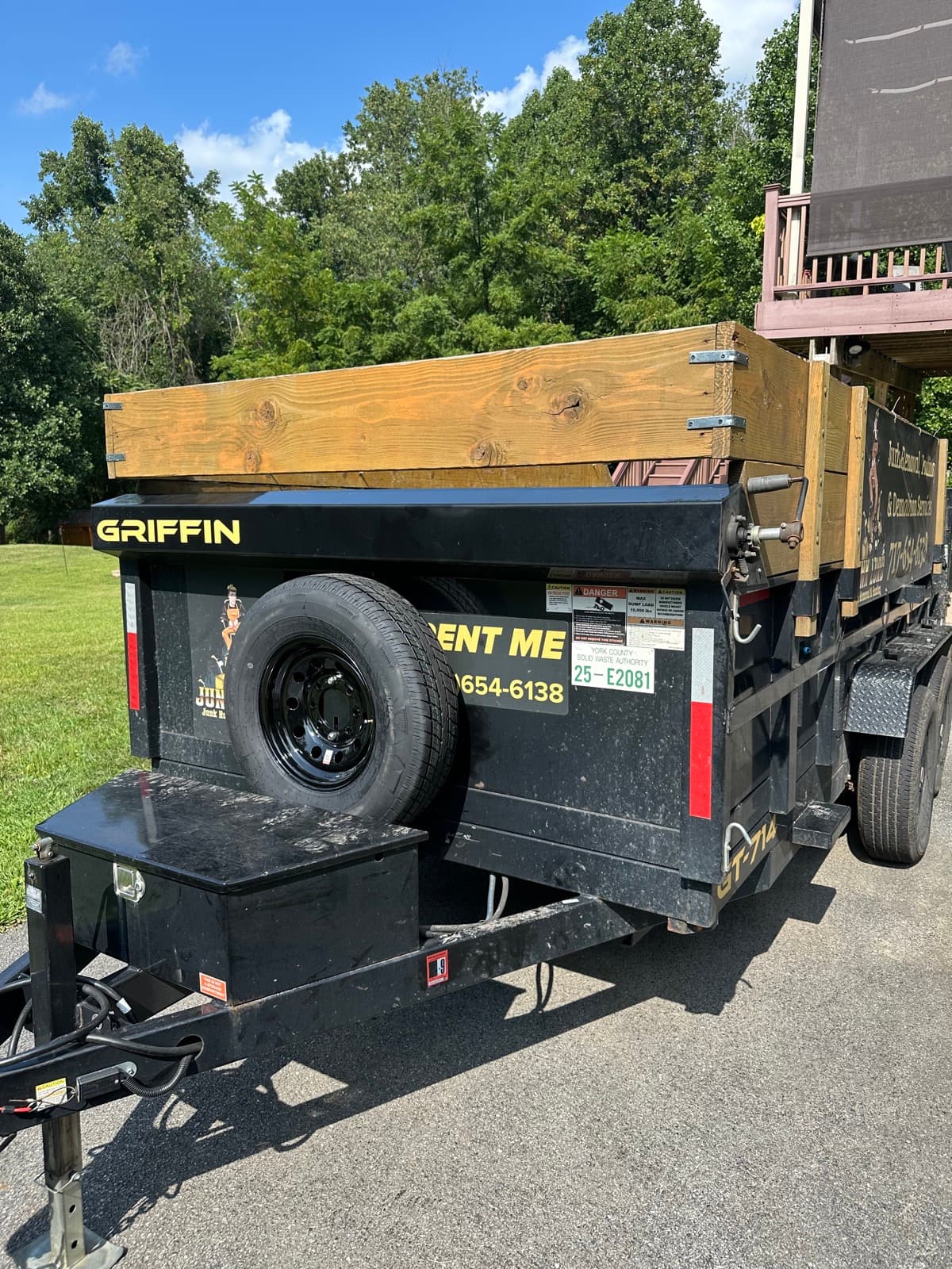 Empty Junk Lord Griffin dump trailer with a clean wood-floor bed, parked and ready to rent out — York County, PA