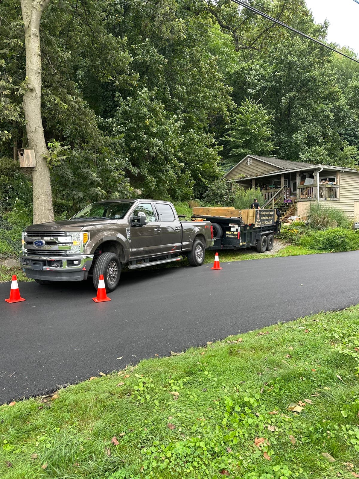 Junk Lord pickup and dump trailer parked in a York County, PA driveway with safety cones set around the rig