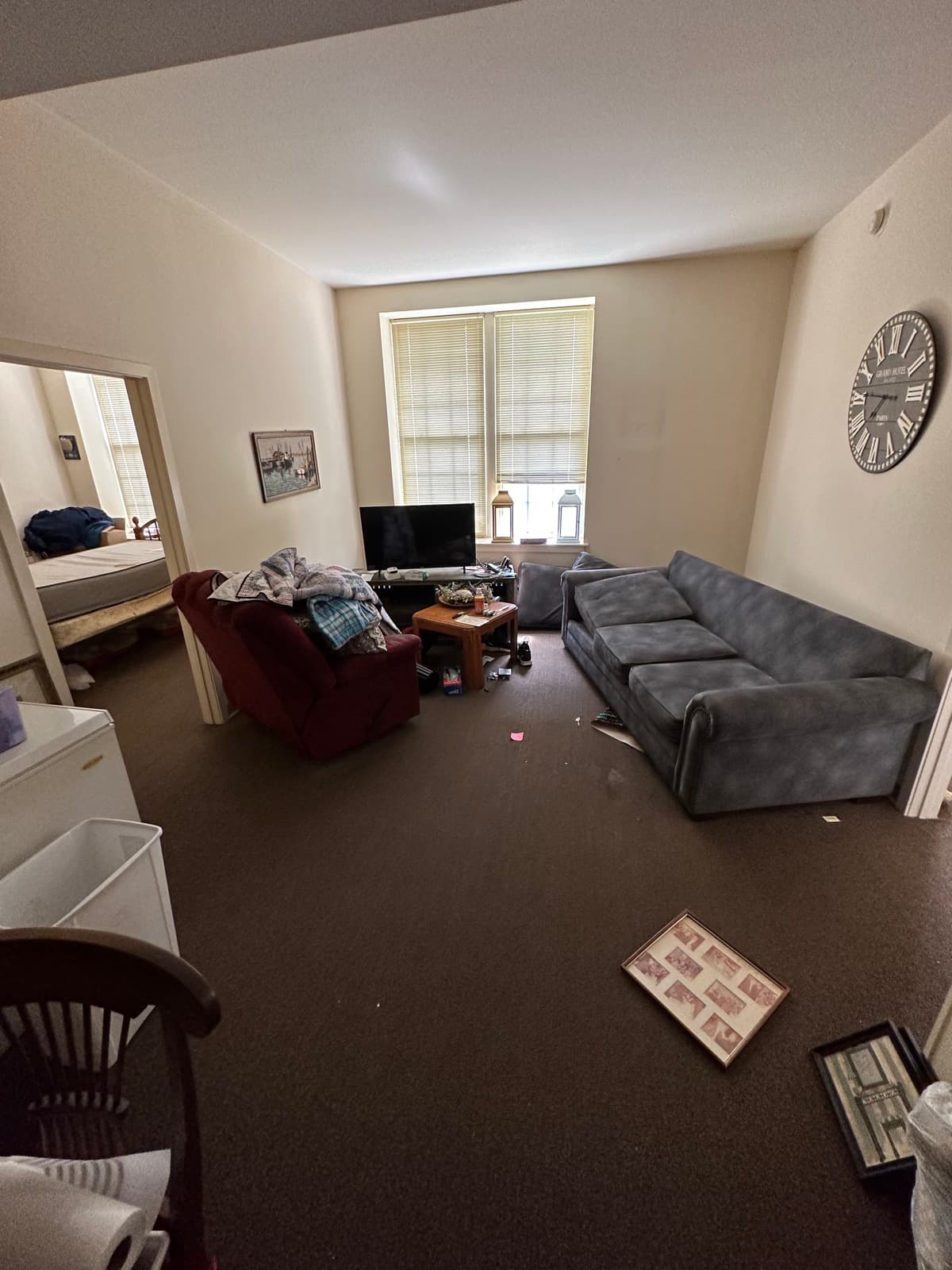 Estate cleanout in a York County, PA living room — gray sectional sofa and remaining household items staged before haul-out
