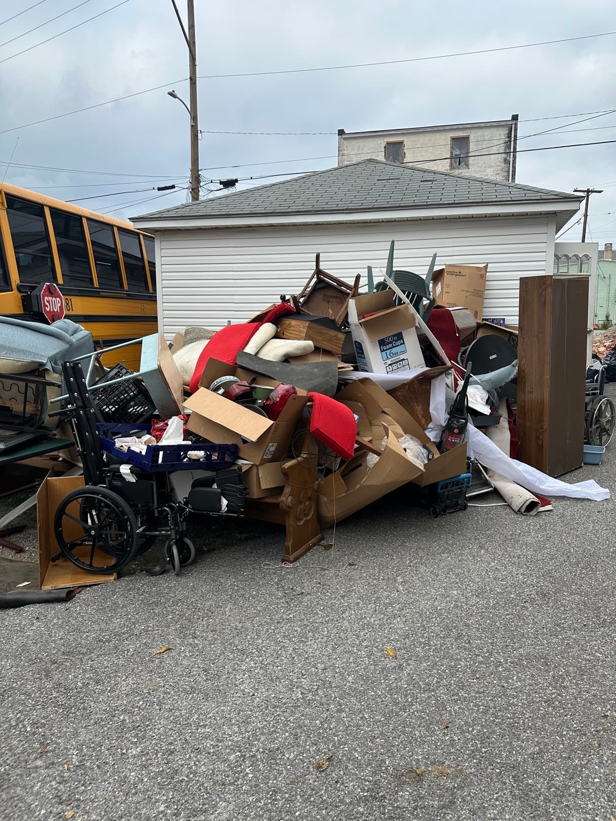Curbside pile of estate cleanout debris — chairs, a wheelchair, dressers, and boxed household goods staged for the dump trailer in York County, PA