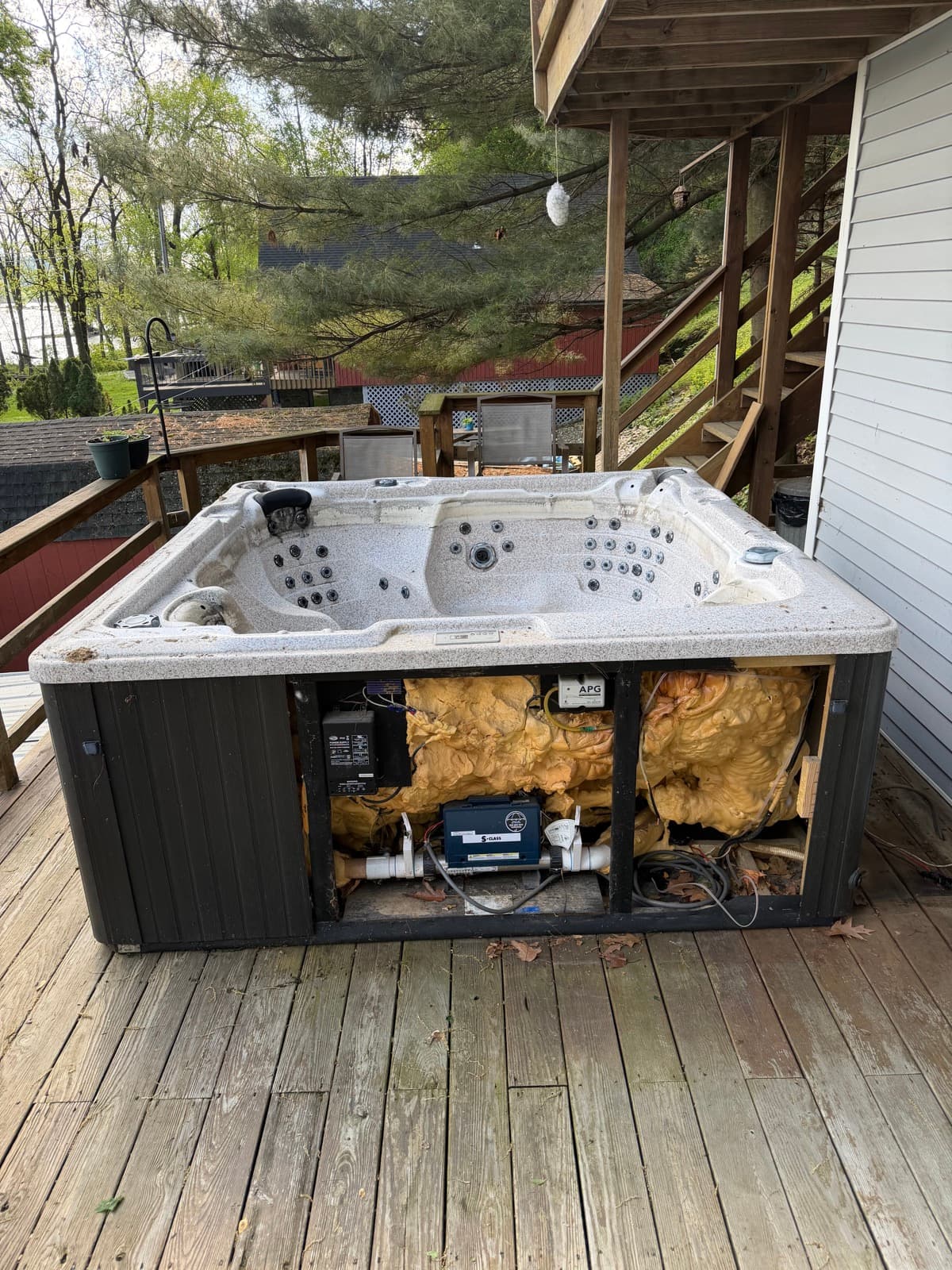 Old white hot tub on a York County deck with the side panel removed for disassembly — The Junk Lord mid-prep
