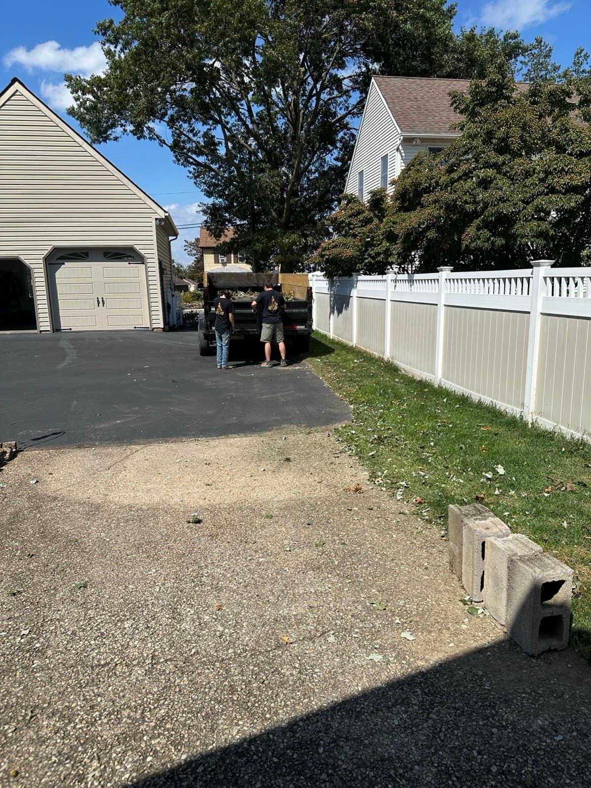 Cleared yard with a vinyl fence after a Junk Lord brush removal